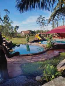 a swimming pool in a yard next to a resort at Cabañas Mountain River Lake Inn in Nueva California