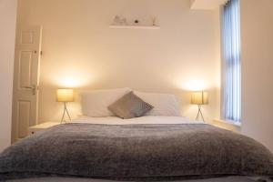 sypialnia z dużym łóżkiem z 2 lampami w obiekcie Central 2-Bedroom Apartment with Wifi in Kettering by HP Accommodation w mieście Kettering