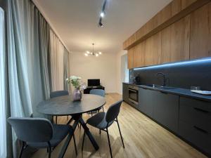 una cucina con tavolo, sedie e lavandino di Marcelin Business & Family a Poznań