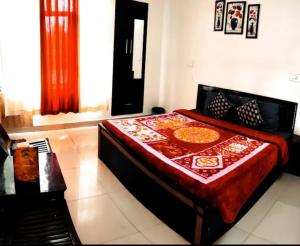 a bedroom with a bed with a red comforter at HOTEL AVI IN DALHOUSIE BANIKHET in Banikhet +1 photo