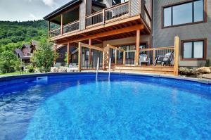 a large swimming pool in front of a house at The Big Jack Chalet 33 Chemin Blanc by Les Chalets Alpins in Stoneham