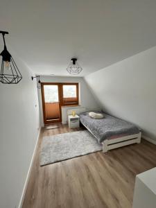 Schlafzimmer im Dachgeschoss mit 2 Betten und einem Fenster in der Unterkunft Dom w Beskidach in Zagórnik