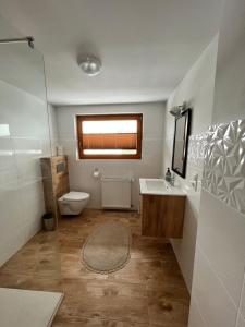 a bathroom with a toilet and a sink and a mirror at Dom w Beskidach in Zagórnik