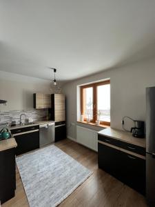 eine Küche mit schwarzen Schränken und einem großen Fenster in der Unterkunft Dom w Beskidach in Zagórnik