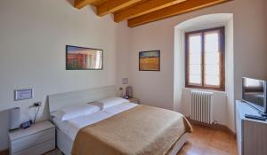1 dormitorio con 1 cama y TV en CAV MOTTENO, en Mandello del Lario