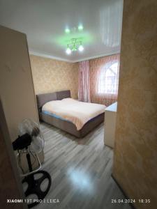 1 dormitorio con 1 cama y 1 cámara en una habitación en Уютная квартира комфорт класса74, en Astana