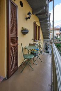 eine Terrasse mit Tisch und Stühlen auf einem Balkon in der Unterkunft CAV MOTTENO in Mandello del Lario