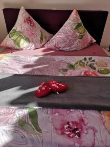 two red shoes are sitting on a bed at Hotel Waldsee in Waldachtal