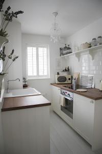 Una cocina blanca con fregadero y microondas. en Maison 5, en Harrogate