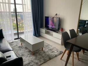 - un salon avec une télévision, une table et des chaises dans l'établissement Hanoi Home 4 - Cool Homestay in Vinhomes Ocean Park, à Hanoï