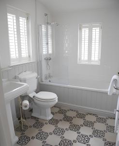 Un baño blanco con inodoro y ducha. en Maison 5, en Harrogate
