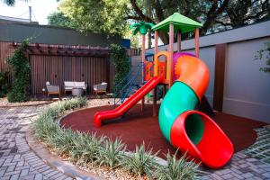 un parque infantil con un tobogán en un patio en Foz Plaza Hotel en Foz de Iguazú