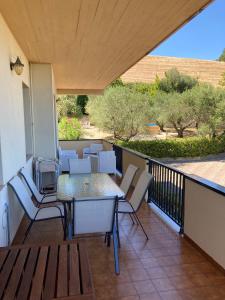 patio con mesa y sillas en el balcón en La Foresteria- Azienda agricola Garra, en Mutignano