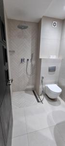 een witte badkamer met een toilet en een douche bij Fnideq Seaside Apartment in Fnidek