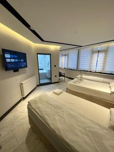 a bedroom with two beds and a flat screen tv at Antik Otel in Kayacık