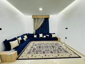 - un salon avec un canapé bleu et un tapis dans l'établissement Agharina furnished apartments, à Nouakchott