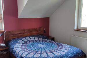 a bed with a blue and white comforter in a bedroom at House at the titbird hill in Kraków