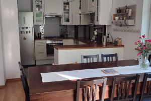 una cocina con mesa de madera y una cocina con armarios blancos. en House at the titbird hill en Cracovia