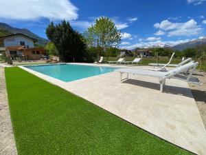 una piscina con banco y césped verde en Villa Carlotta Verde en Colico