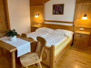 a bedroom with a bed and a table and chairs at Stoanahof in Virgen