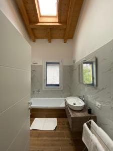 y baño con lavabo y bañera. en Villa Carlotta Verde en Colico