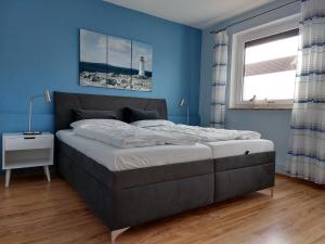 a bedroom with a large bed with a blue wall at Haus Schwalbennest in Dahme +13 photos