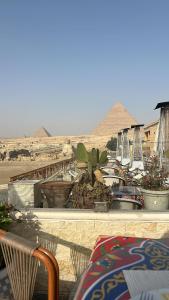 a view of the pyramids from a balcony with tables and chairs at Queen cleopatra sphinx view in Cairo