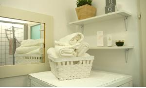 a bathroom with white towels in a basket in front of a mirror at Spacious 2Rooms in the Center in Vienna
