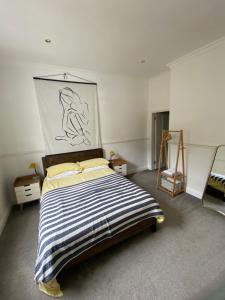 a bedroom with a bed and a painting on the wall at The Cafe Apartment in Great Malvern