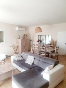 ein Wohnzimmer mit einem Sofa und einem Tisch in der Unterkunft La villa Louca in Saint-Saturnin-dʼApt