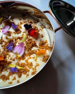 a bowl of cereal with a flower on it at Villa Zara Boutique Hotel Resort in Smolník