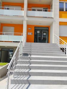 una escalera que conduce a un edificio con una puerta naranja en Apartman Branković Pirot-Zapadni Kej 58, en Pirot