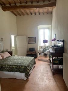 una camera con letto, scrivania e pianoforte di Dimora Scarnabecco a Todi