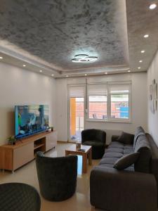a living room with a couch and a tv at Apartman Branković Pirot-Zapadni Kej 58 in Pirot