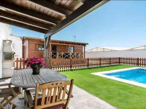 een patio met een tafel en een zwembad bij Bungalow para familias y parejas in Cádiz