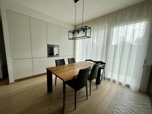 a dining room with a wooden table and black chairs at Villa Illumina Venice in Venice