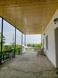 eine leere Veranda mit einem Holzdach und einer Bank in der Unterkunft My home in Kutaissi