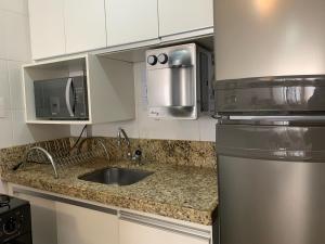 uma cozinha com um lavatório e um frigorífico em Apartamento aconchegante no setor Bueno NW1006 em Goiânia