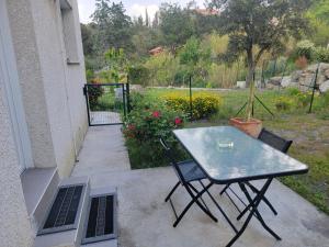 a table and chairs on a patio with a garden at Appartement au cœur des Albères in Le Boulou