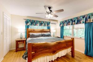 a bedroom with a wooden bed and a ceiling fan at Bradley Bear Hideaway in Maggie Valley