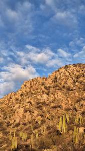 una montaña rocosa con cactus a un lado en Casa Kuntur in 