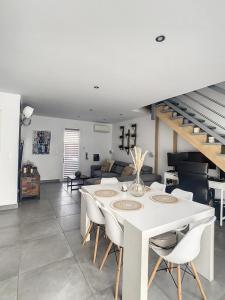 ein Wohnzimmer mit einem weißen Tisch und Stühlen in der Unterkunft Villa T4 avec Piscine et cuisine d'été in La Seyne-sur-Mer