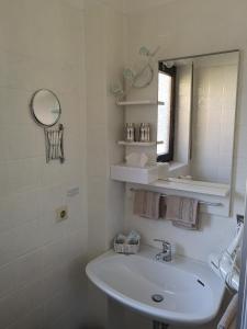 a white bathroom with a sink and a mirror at Hotel Waldsee in Waldachtal