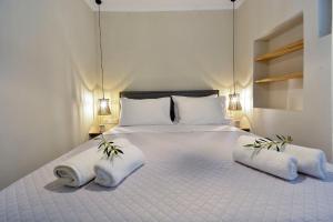 a bedroom with a large white bed with two pillows at Island Suite, Old Town in Corfu