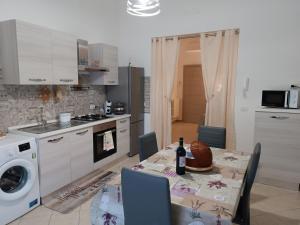 a kitchen with a table with a bottle of wine on it at Storm Sonic House in Palo del Colle