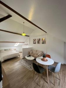 een woonkamer met een bank en een tafel en stoelen bij Studio confortable et fonctionnel proche gare in Méru