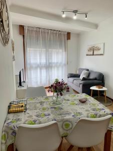 Una sala de estar con una mesa y sillas y un sofá. en Plaza America Home, en Vigo