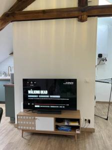 TV de pantalla plana en la parte superior de una pared en Studio confortable et fonctionnel proche gare en Méru