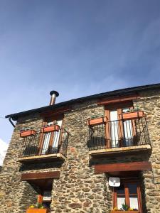 - un bâtiment en pierre avec des balcons sur le côté dans l'établissement Apartamento Forn de Serra, à Lladorre