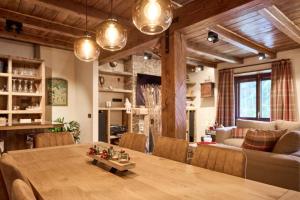 a dining room with a table and a living room at Pleta del Tarter 31A Lodge & SPA in Canillo